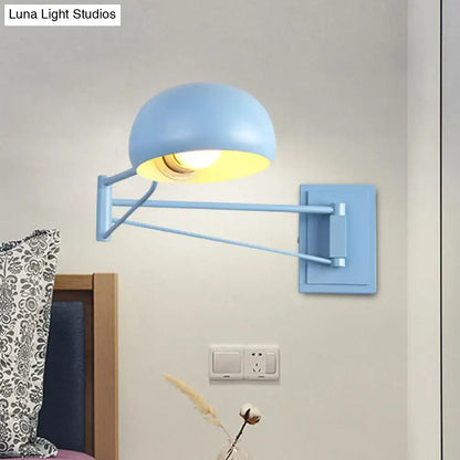 Blue adjustable metal wall sconce with bowl shade mounted beside bed in bedroom on Tampa Home & Garden Store