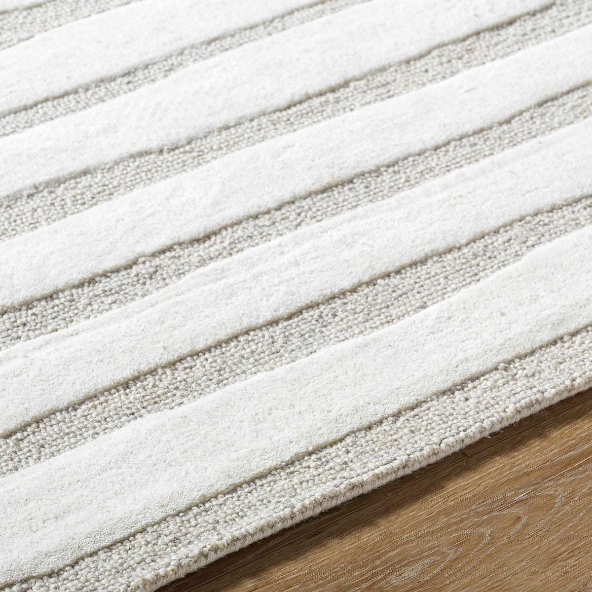 Zerah Area Rug ivory and beige striped pattern on wood floor on Tampa Home & Garden Store