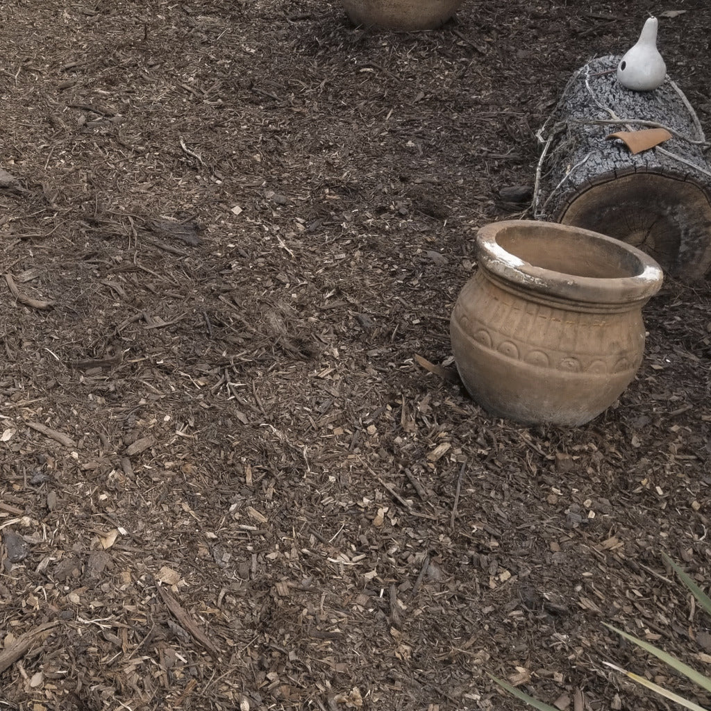 Bulk brown mulch delivered and spread on a landscape garden.